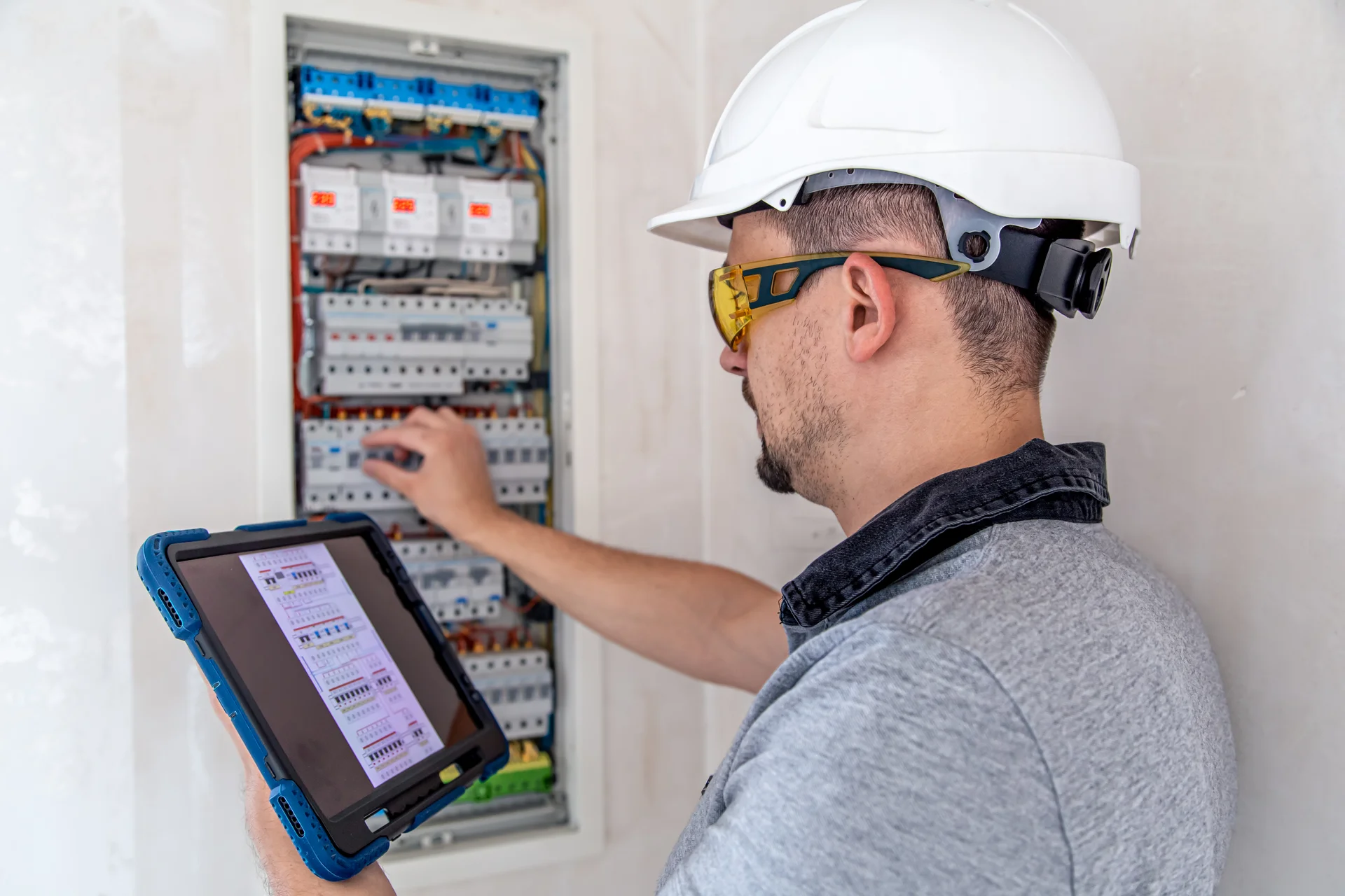 electrical-technician-looking-focused-while-working-switchboard-with-fuses